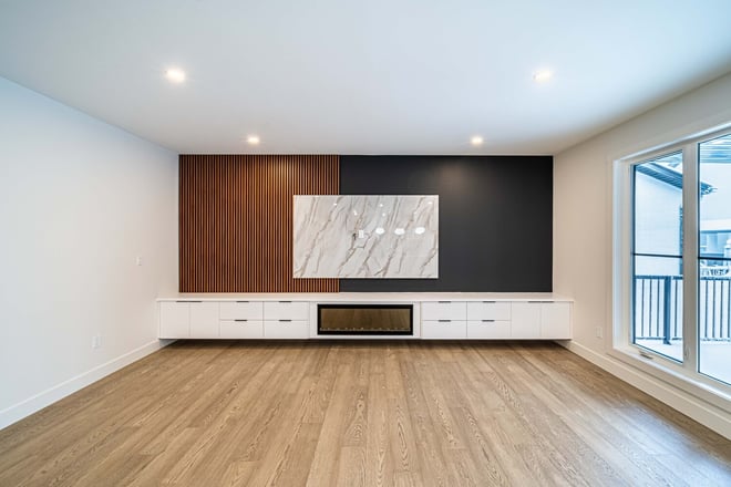 Contemporary living room design with wood accents and marble paneling by Bright Custom Homes in Calgary
