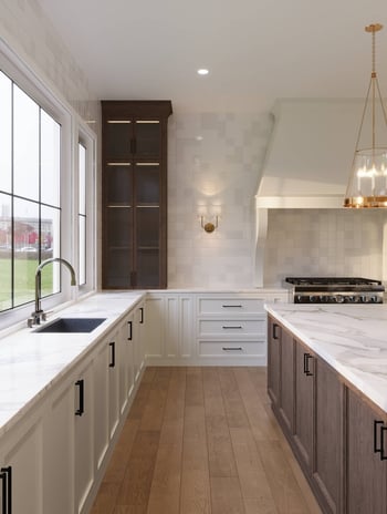 Bright Custom Homes custom kitchen with marble countertops and gas range in Bankview, Calgary.