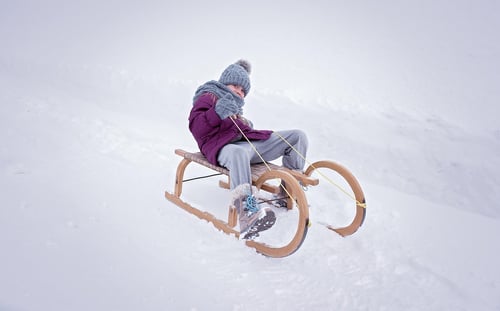 Image of a young girl tobogganing down a sled in Calgary